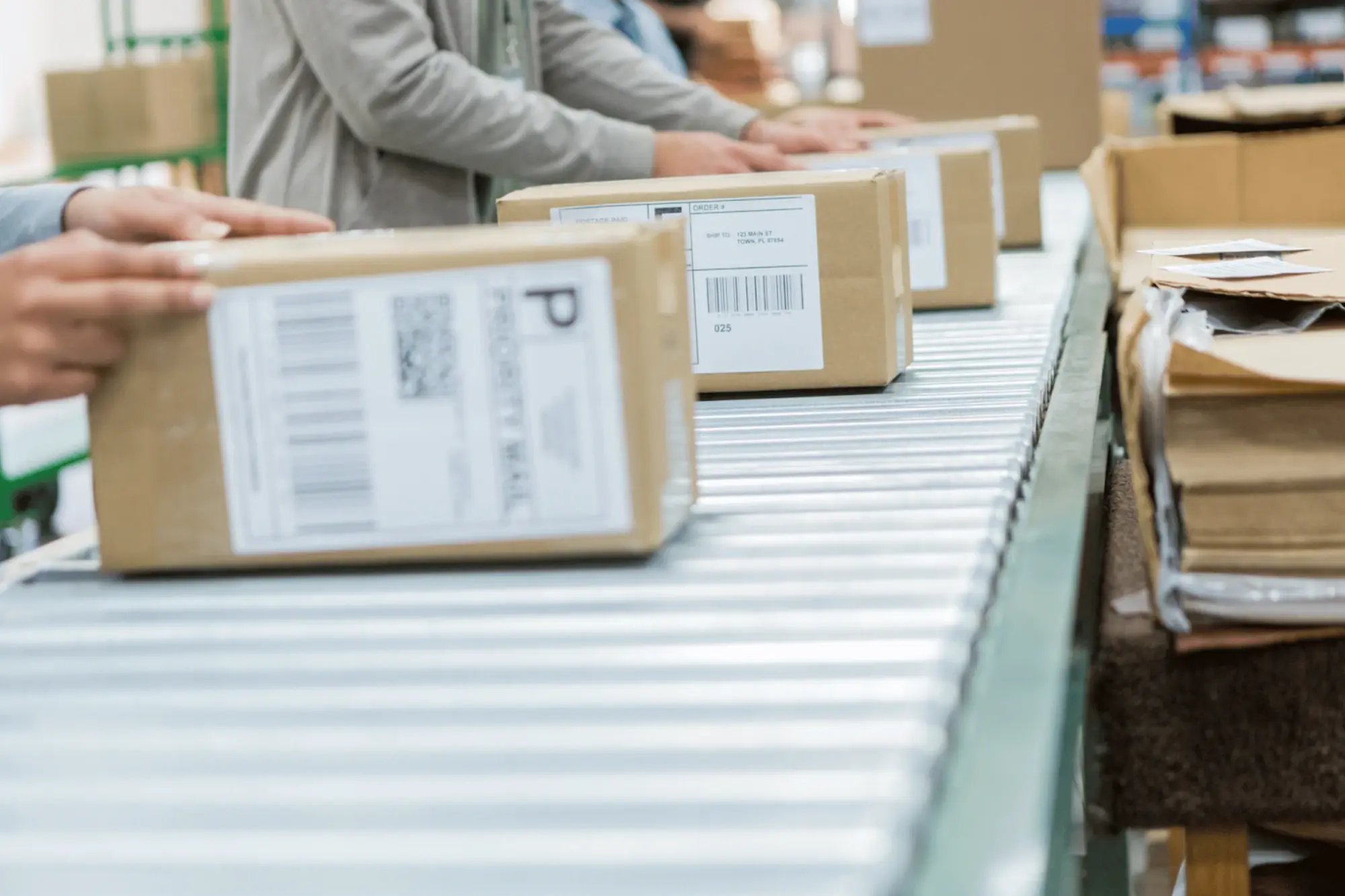 Automated conveyor line moving packages through a warehouse for B2B order fulfillment and processing.