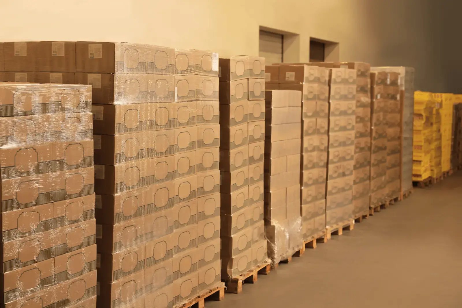 Stacked boxes in a warehouse, representing goods managed with B2B customer portals.